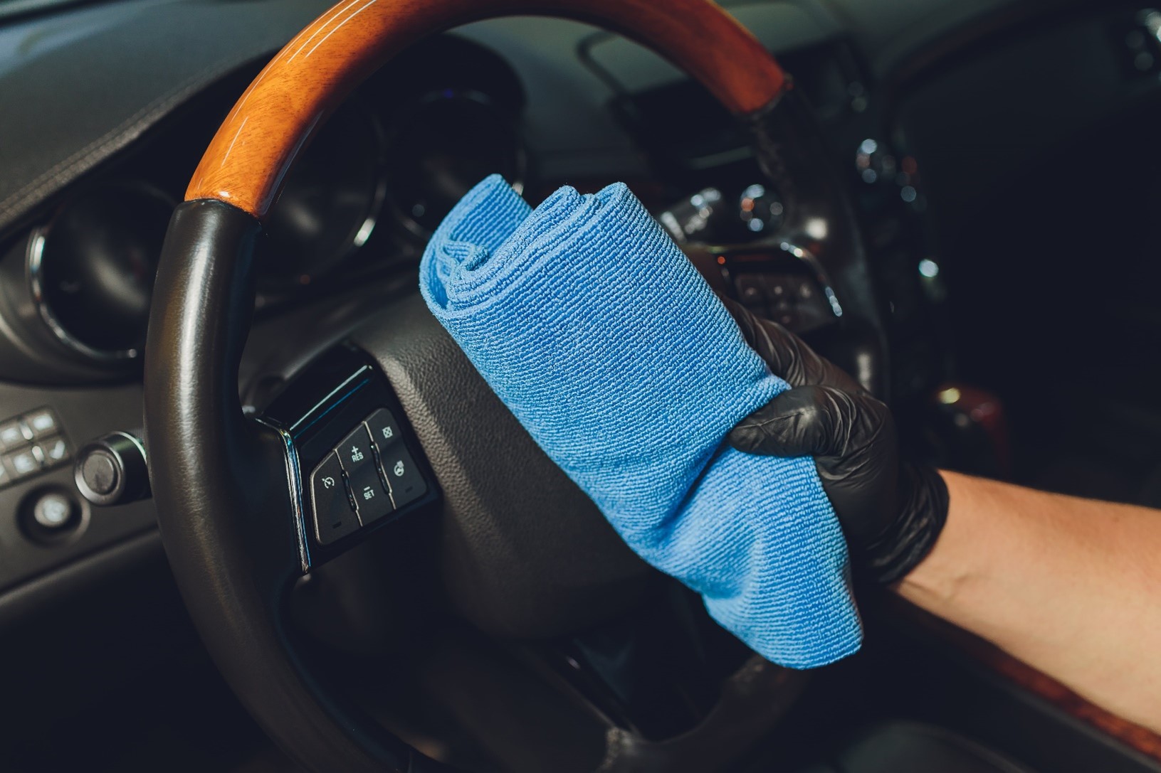 Person holding a blue cloth for a car valet service